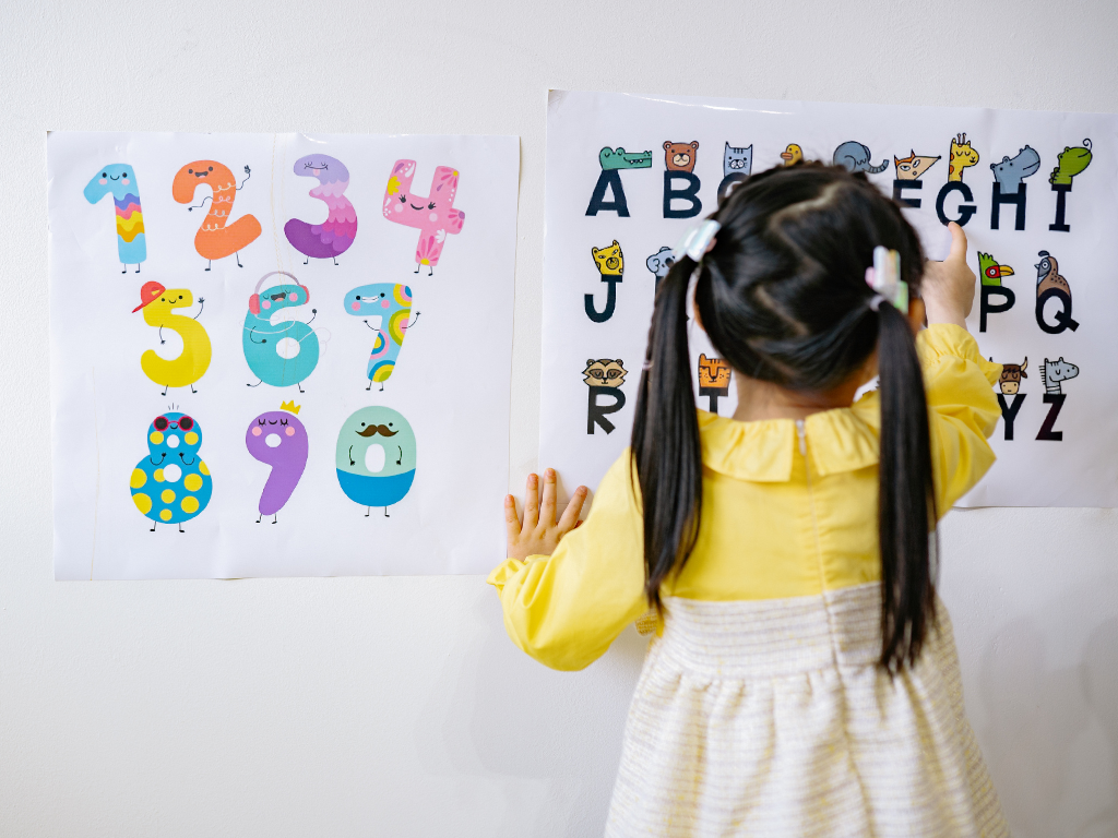 Dziecko uczące się liczb i liter podczas zajęć edukacyjnych w przedszkolu