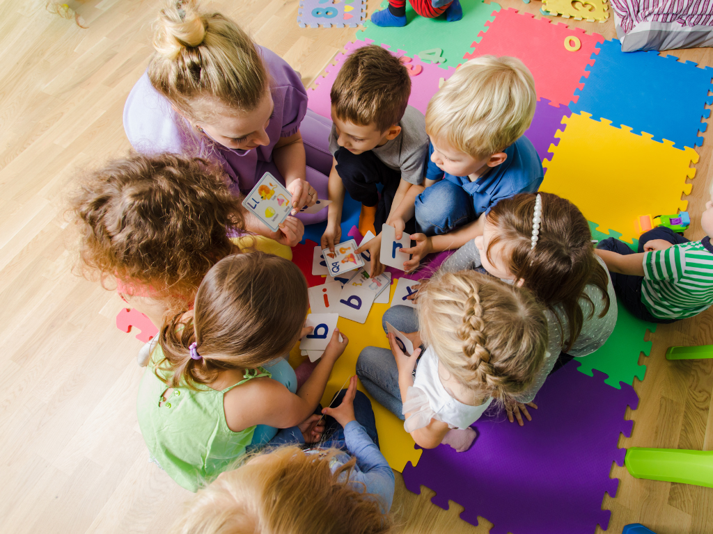 Dzieci bawiące się wspólnie na macie podczas zajęć w przedszkolu terapeutycznym